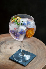 Gin and tonic with rosemary and borage flowers ice cubes