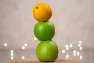 still life with fresh apples and lemons with lights in the background