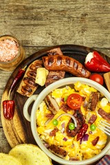 Scrambled egg with grilled sausage. Protein diet. A generous breakfast. Food preparation.