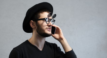 Portrait of smiling hipster man talking on smartphone.