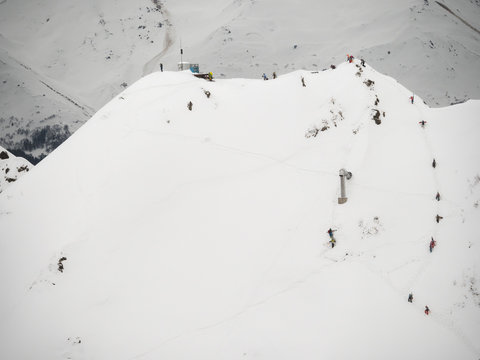 group of freeriders snowboarders skiers rises uphill in the Caucasus in the rose khutor