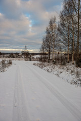 Obraz premium snow covered winter road with tire tracks