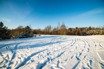 snow covered winter road with tire tracks