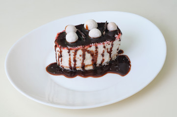 Coffee cake with coconut and chocolate on white plate