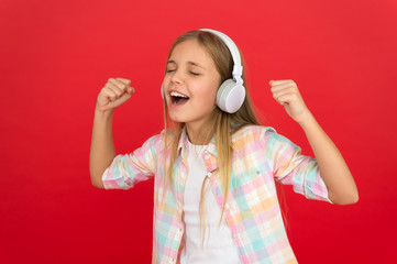 Little girl listen song headphones. Online radio station channel. Girl child listen music modern...