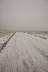 snow covered winter road with tire tracks
