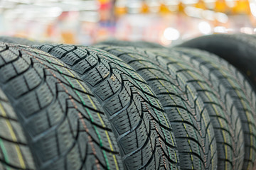 new tires for sale at booth in store. Winter Season Tire Tread. Brand New Car Tires on the Shelf.