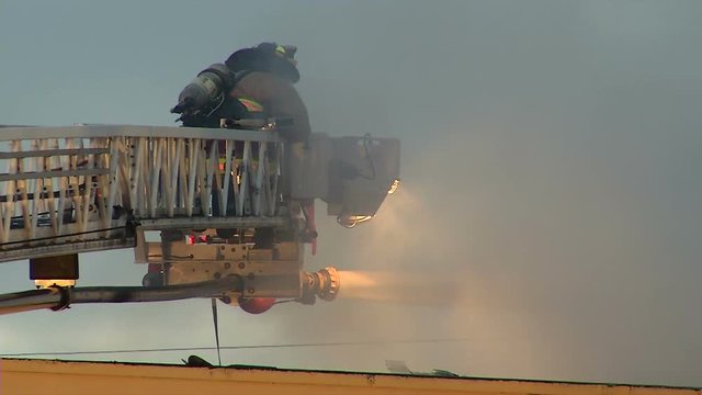 FIREFIGHTER USES WATER CANNON ON TOWER LADDER OF FIRE TRUCK 2