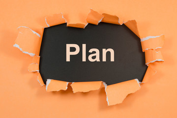 The words plan appearing behind torn paper