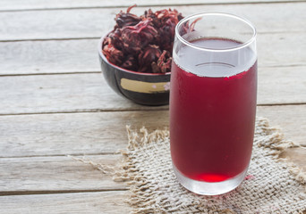 Roselle juice on wooden background, roselle juice in glass on sack,