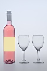 bottle and glass of pink wine isolated on white background