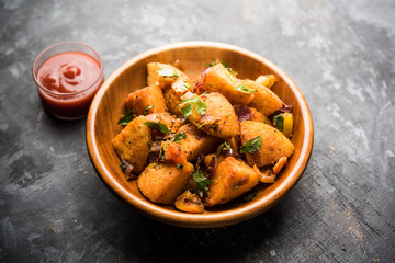 Masala fried Idlies or Idli fry - south indian Snack made using with leftover idly served with tomato ketchup. selective focus