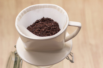 Drip coffee with paper filter tool on wood background