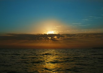 Blue summer sky and bright orange sea sunset in the clouds