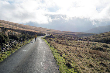 road in mountains with a lady with dogs in brecon beacons 