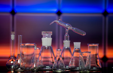 Empty chemical glassware on color background. Group of laboratory empty flasks   on color scientific background reflection on a table