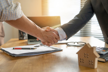 Banker business man shaking hands with client and sign contrac document for comfirm corporation or finished loan agreement for house or building property.Document in photo is fake only for stock photo