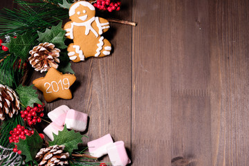 ginger biscuit and marshmallow on brown background with Christmas tree ,  candles and christmas lights. Copy space