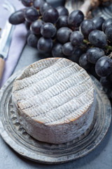 Whole round mature French Tomme cheese close up