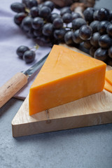 Piece of hard orange Cheddar cheese close up