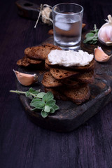 Rye bread toasts with lard paste on a black board. Ukrainian cuisine appetizer