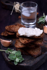Rye bread toasts with lard paste on a black board. Ukrainian cuisine appetizer