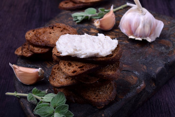 Rye bread toasts with lard paste on a black board. Ukrainian cuisine appetizer