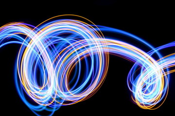 Light painting photography, blue and gold loops and swirls of vibrant color, long exposure photo of...