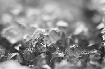 Black and white photograph of the structure of the surface of crystals. Close-up. Blurred background.