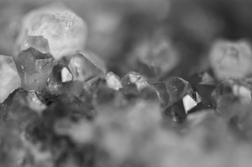 Black and white photograph of the structure of the surface of crystals. Close-up. Blurred background.