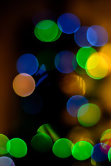 bokeh blue, green, yellow, red tones on black background on New Year's Eve