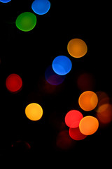 bokeh blue, green, yellow, red tones on black background on New Year's Eve