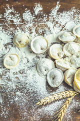 Italian ravioli, dumplings with meat on dark wooden old surface