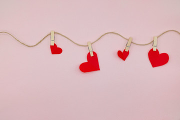 Valentine day background with red hearts hanging on the clothesline.