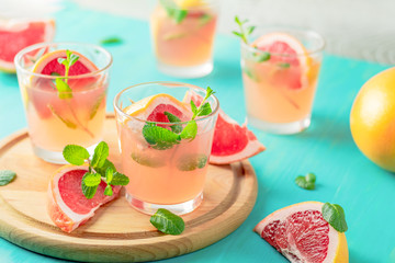 Fresh pink alcoholic cocktail with grapefruit, ice and mint
