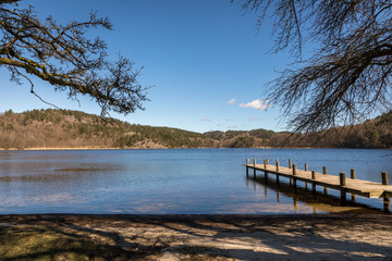 Fototapeta premium Dock by the lake in Norway, early spring at Tjomsevannet in Sogne.