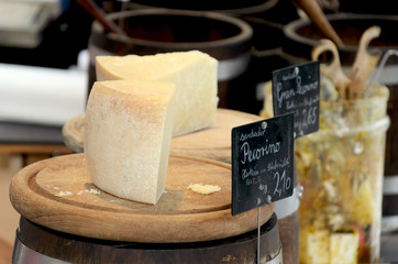 Italian cheeses on wooden plates in a farmers market.