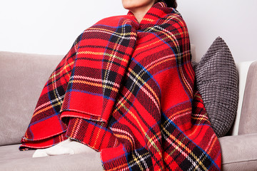 Woman feeling freeze and wrap up in a blanket.