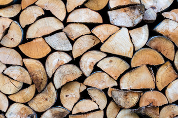 Dry chopped firewood logs in a pile. Background texture