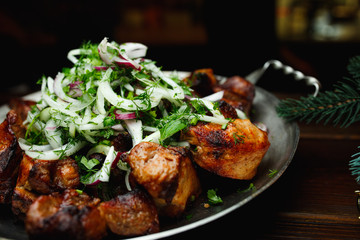 Shish kebab, kebab on a dark background. Different fried meat in plate