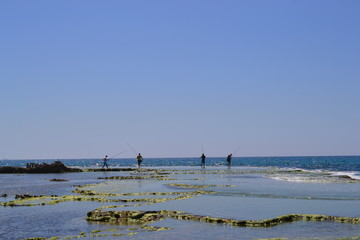 fisher men standing at Coast landscape of Caesarea Maritima, Mediterranean Sea, Israel