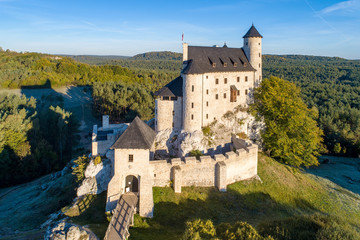Obraz premium Średniowieczny zamek w Bobolicach, Polska, zbudowany w XIV wieku, odnowiony w XX wieku. Jedna z warowni zwanych Orlimi Gniazdami w Polskiej Jurajskiej Wyżynie na Śląsku. Widok z lotu ptaka w świetle wschodu słońca