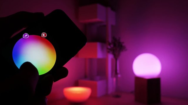 mart home lighting technology, controlling color of a bulb and scheduling time with a smart phone. Remote controlling light with a phone app. 4k Video C  By Cristiano Paradiso