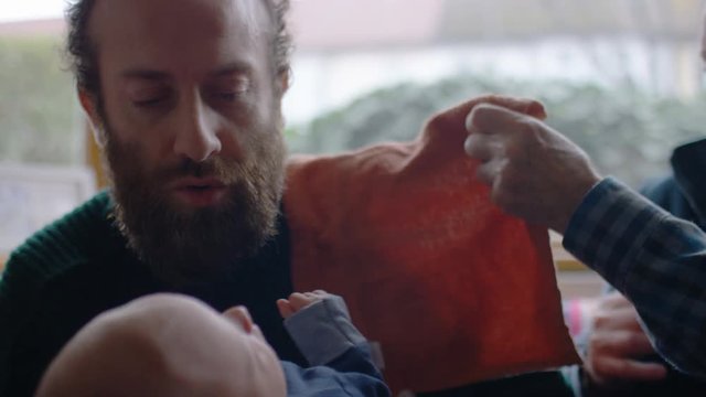 New father hands his baby over to his father