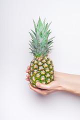 Ripe pineapple woman's in hand isolated on white background.