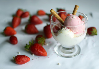 A cup of ice cream with strawberries and rolled wafers. ice cream closeup.