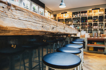 Row of empty black stools chairs at the bar