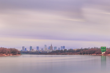 Peaceful Warsaw skyline with view of the skyscrapers in the downtown at the end of the shorlines of the Vistula River in pastel colors