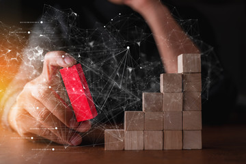 business man try to choose red color wood block from others on wooden table and black background...