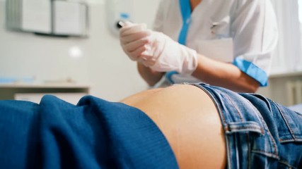 Woman doctor makes an intramuscular injection to the gluteus maximus muscle. - Powered by Adobe